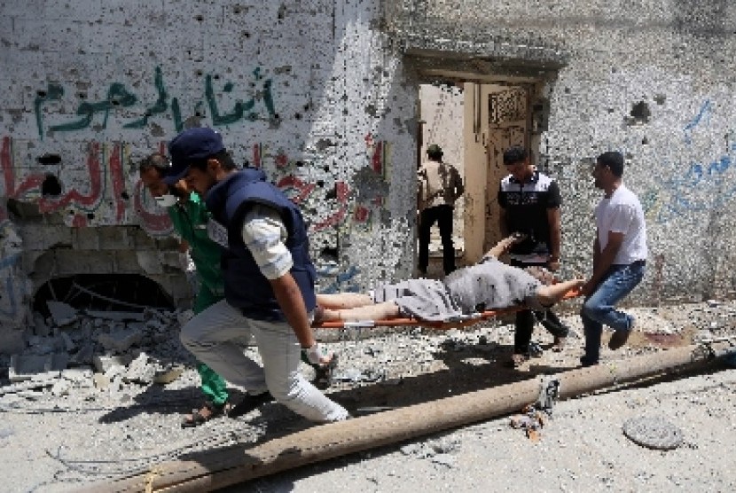 Paramedis membawa jenazah pria yang tewas akibat serangan Israel di Distrik Sijaiyah, Gaza utara.