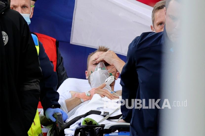 Pesepak bola Christian Eriksen ditandu dari lapangan setelah pingsan saat pertandingan Grup B kejuaraan sepak bola Euro 2020 antara Denmark dan Finlandia di Stadion Parken di Kopenhagen, Denmark, Sabtu (12/6). Ia telah dipasangi implan ICD untuk membantu kinerja jantungnya.