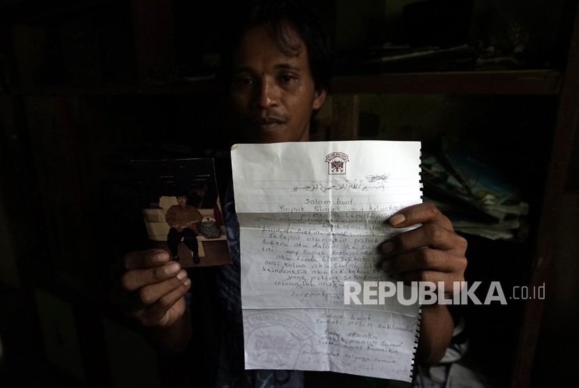 Parsin, anak kedua dari Parinah, TKW Indonesia yang telah hilang selama 18 tahun, menunjukan foto ibunya. Hari ini, dijadwalkan Parinah akan tiba di Tanah Air setelah difasilitasi pemulangannya oleh KBRI di Inggris.