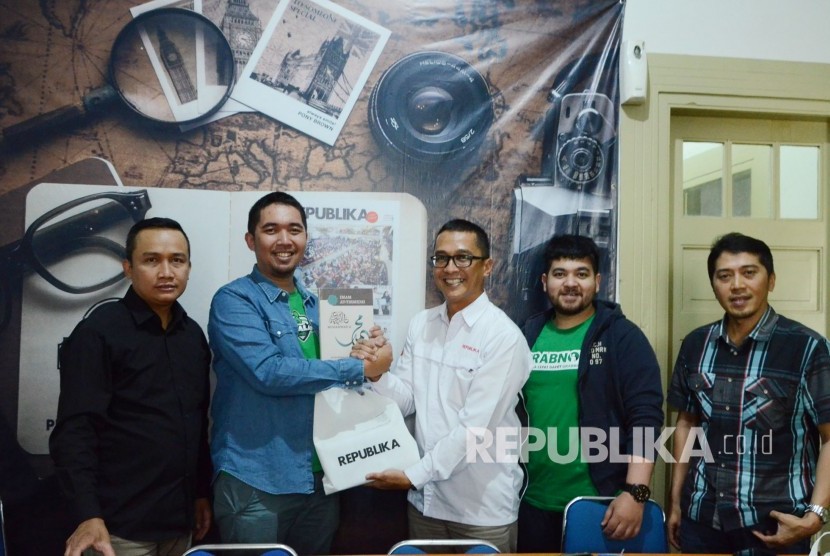 Partner Grab Jawa Barat Mawaddi Lubby (kedua kiri) menerima cinderamata buku terbitan Republika dari Kepala Perwakilan Republika Jawa Barat Rachmat Santosa Basarah saat berkunjung ke Kantor Republika Jawa Barat, Jalan Mangga, Kota Bandung, Kamis (25/7).