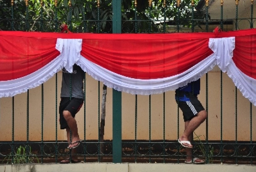 PASANG ATRIBUT KEMERDEKAAN. Dua orang pekerja memasang atribut merah putih di Jalan Tanah Abang, Jakarta.