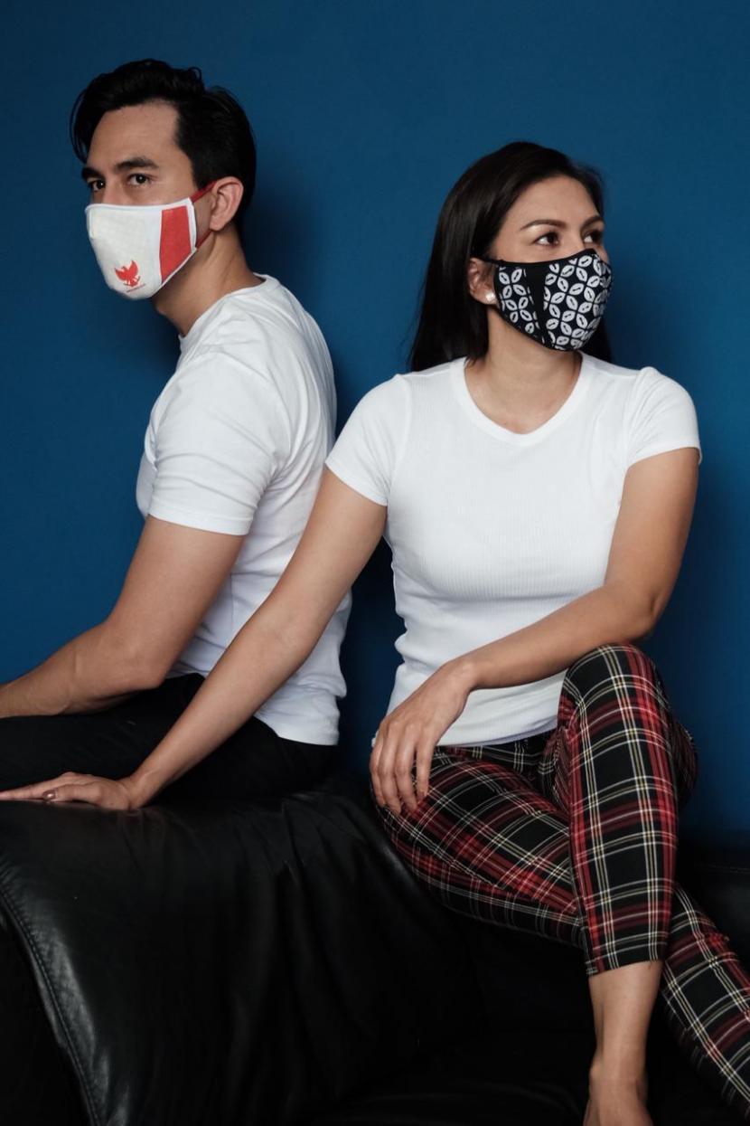Pasangan artis Darius Sinatrya dan Donna Agnesia memakai masker rancangan Ferry Sunarto