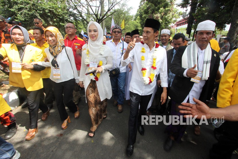 Pasangan bakal Calon Bupati Bogor Ade Ruhandi (kanan) dan Inggrid Kansil (kiri) bersama pendukungnya berjalan menuju KPUD Kabupaten Bogor, Cibinong, Bogor, Jawa Barat,Rabu (10/1). 