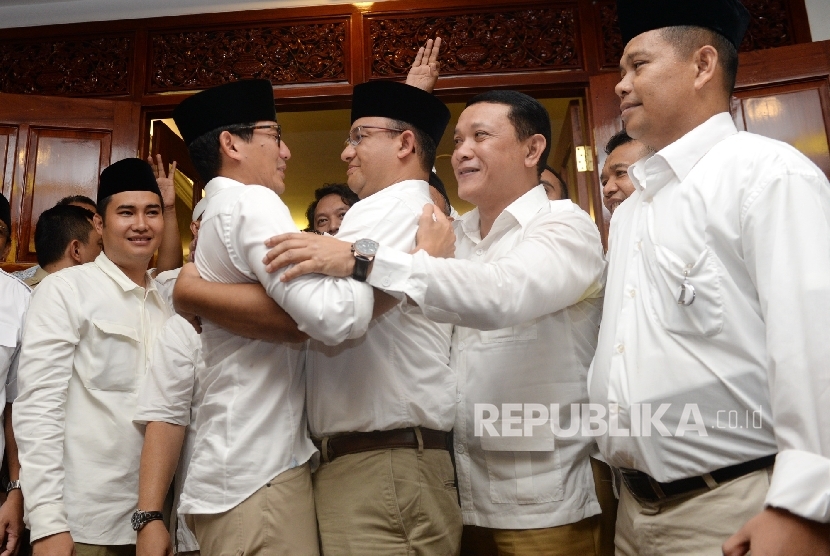 Pasangan Cagub Cawagub DKI Jakarta Anies Baswedan dan Sandiaga Uno berpelukan usai menggelar konferensi pers di Posko Pemenangan Paslon Anies-Sandi Kertajaya, Jakarta, Rabu (19/4).