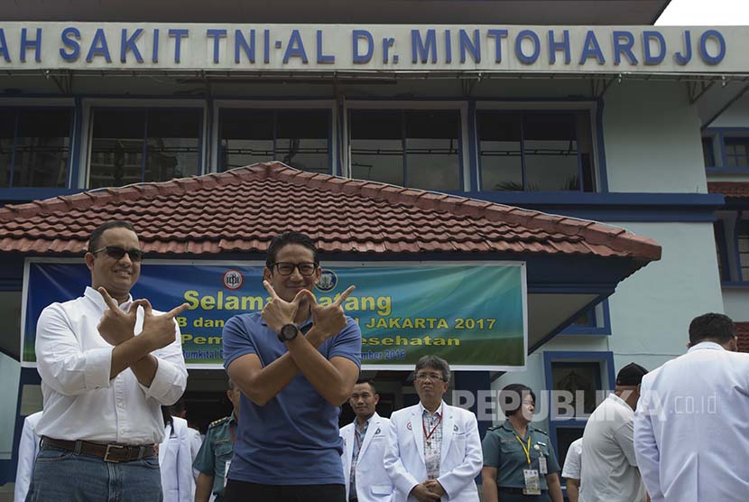 Pasangan Cagub dan Cawagub DKI Jakarta Anies Baswedan (kiri) dan Sandiaga Uno (kedua kiri) berpose saat tiba sebelum menjalani tes kesehatan di RSAL Mintohardjo, Jakarta, Sabtu (24/9). 