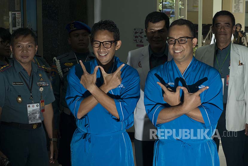 Pasangan Cagub dan Cawagub DKI Jakarta Anies Baswedan (kiri) dan Sandiaga Uno (kedua kiri) berpose saat tiba sebelum menjalani tes kesehatan di RSAL Mintohardjo, Jakarta, Sabtu (24/9). 