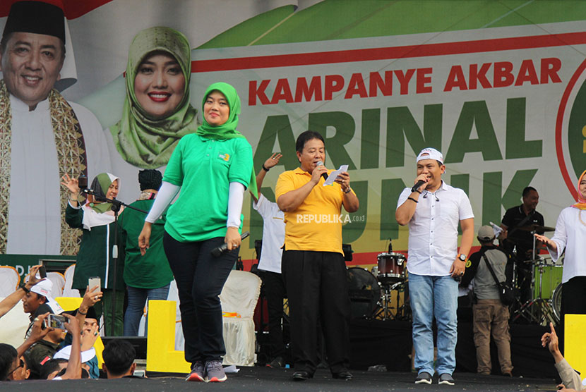 Pasangan calon gubernur dan wakil gubernur Lampung nomer urut tiga Arinal Djunaidi (tengah) dan Chusnunia Chalim (kiri) bernyanyi bersama vokalis Wali Band Faang (kanan) saat menggelar kampanye akbar di Bandar Jaya, Lampung Tengah, Lampung, Minggu (22/4). 