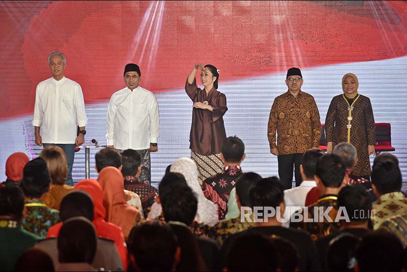 Pasangan calon gubernur dan wakil gubernur nomor urut satu Ganjar Pranowo (kiri)-Taj Yasin (kedua kiri) dan pasangan nomor urut dua Sudirman Said (kedua kanan)-Ida Fauzia (kanan) menyanyikan lagu kebangsaan Indonesia Raya.