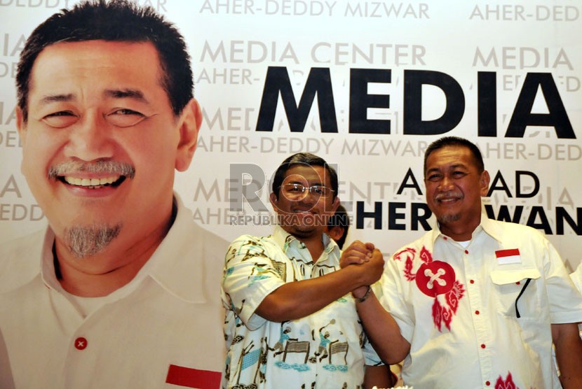  Pasangan calon gubernur Jabar Ahmad Heryawan-Deddy Mizwar bersalaman saat memantau hasil perhitungan cepat (Quick Count) di Media Center Aher-Deddy di Bandung, Ahad (24/2).  (Republika/Prayogi)
