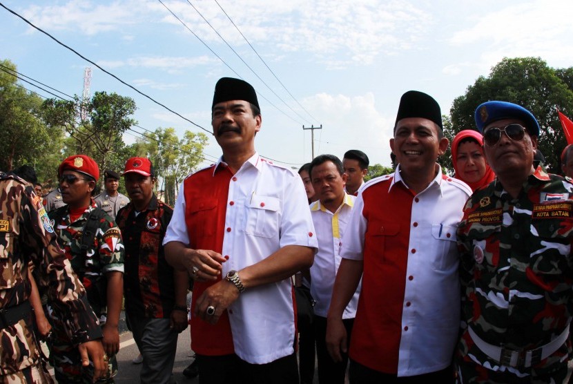 Pasangan Calon Gubernur Kepulauan Riau (Kepri) Soeryo Roespationo (kiri) dan wakilnya Ansar Ahmad dikawal pendukungnya saat mendaftar Pilkada di KPU Provinsi Kepri, Tanjungpinang, Kepri, Senin (27/7). 