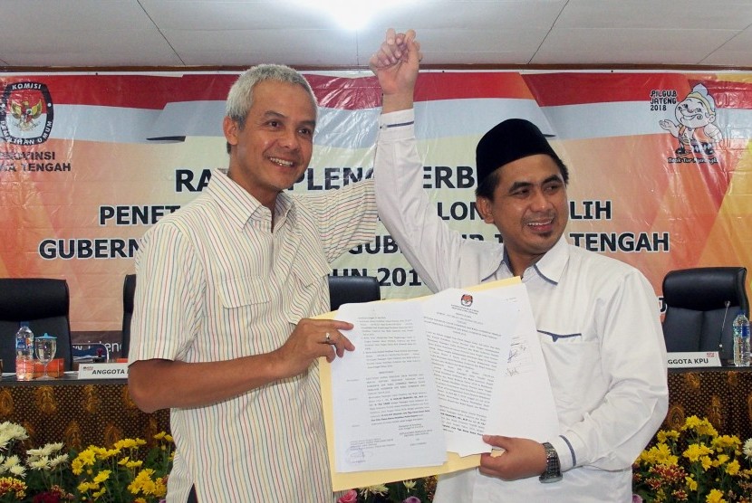 Pasangan calon terpilih Gubernur dan Wakil Gubernur Jateng, Ganjar Pranowo (kiri) dan Taj Yasin (kanan), memperlihatkan surat keputusan KPU Jateng tentang penetapan paslon gubernur dan wakil gubernur terpilih dalam Pilgub Jateng, pada rapat pleno terbuka di Kantor KPU Jateng, di Semarang, Jawa Tengah, Selasa (24/7).