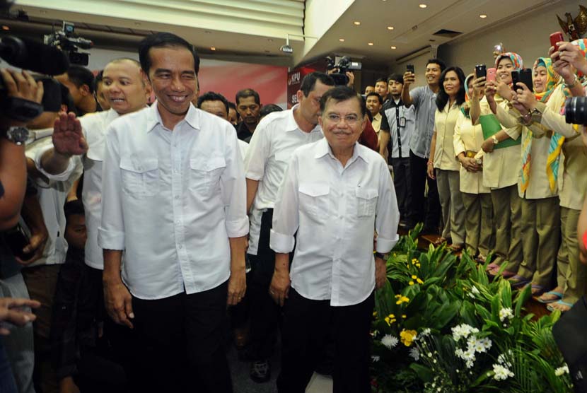 Pasangan Capres-cawapres PDIP Joko Widodo (kiri) dan Jusuf Kalla (kanan) berjalan saat mendatangi Komisi Pemilihan Umum (KPU) di Jakarta, Senin (19/5).