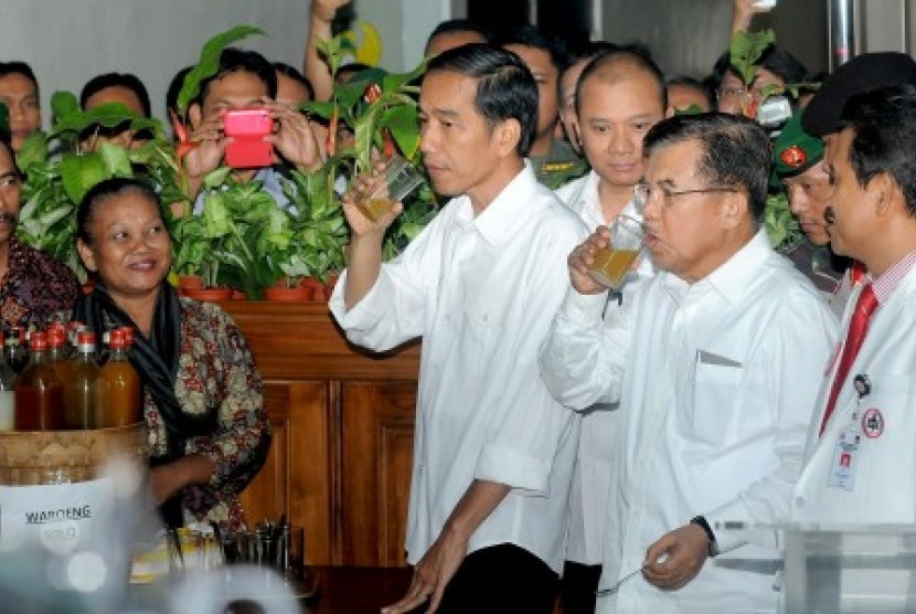 Pasangan Capres dan Cawapres Joko Widodo dan Jusuf Kalla didampingi tim dokter minum jamu seusai menjalani tes kesehatan di RSPAD Gatot Subroto, Jakarta, Kamis (22/5). Pasangan tersebut menjalani tes kesehatan selama sembilan jam sebagai syarat untuk maju 