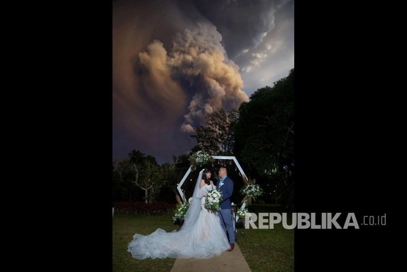 Pasangan di Filipina melaksanakan pernikahannya dengan latar letusan Gunung Taal, Batangas Filipina, Sementara  pernikahan berlangsung di Alfonso, Cavite, Philippines, January 12, 2020, in this image obtained from social media. 