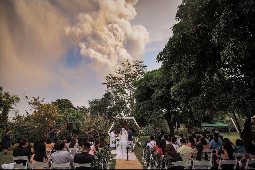Pasangan di Filipina melaksanakan pernikahannya dengan latar letusan Gunung Taal, Batangas Filipina, Sementara  pernikahan berlangsung di Alfonso, Cavite, Philippines, January 12, 2020, in this image obtained from social media. 