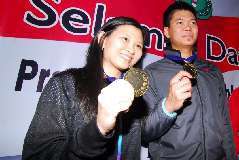 Pasangan ganda campuran Praveen Jordan (kanan), Debby Susanto (kiri) memegang medali sesaat tiba di terminal 2 D bandara Soekarno Hatta, Tangerang, Banten, Selasa (15/3) malam.