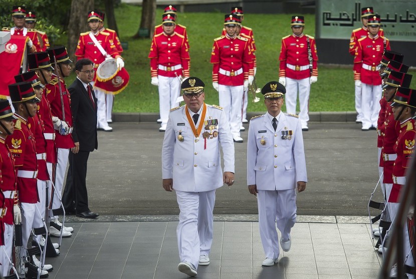 Pasangan Gubernur dan Wakil Gubernur terpilih Bengkulu, Ridwan Mukti (kiri) dan Rohidin Mersyah (kanan) berjalan menuju Istana Merdeka untuk menerima petikan Keppres dari Presiden Joko Widodo di Jakarta, Jumat (12/2).(Antara/Widodo S. Jusuf) 