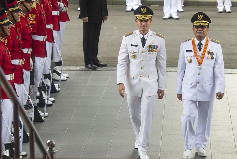 Pasangan Gubernur dan Wakil Gubernur terpilih Jambi, Zumi Zola Zulkifli (kiri) dan Fachrori Umar (kanan) berjalan menuju Istana Merdeka untuk menerima petikan Keppres dari Presiden Joko Widodo di Jakarta, Jumat (12/2). 