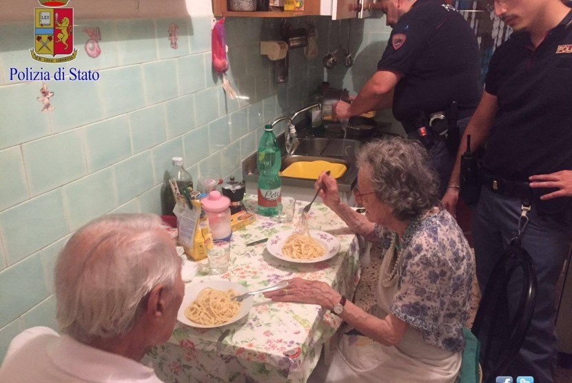 Pasangan Jole dan Michele menikmati pasta yang dimasak petugas Kepolisian Italia di Roma untuk mengusir kesepian mereka.