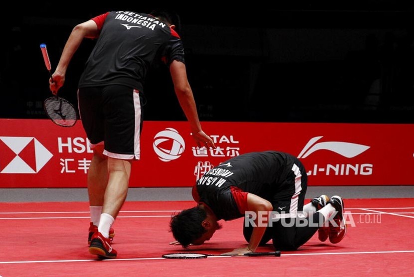 Pasangan Mohammad Ahsan (kanan) dan Hendra Setiawan merayakan kemenangan pada laga final nomor ganda putra melawan pasangan Jepang Hiroyuki Endo dan Yuta Watanabe pada turnamen World Tour Finals di Guangzhou, China, Ahad (15/12) 