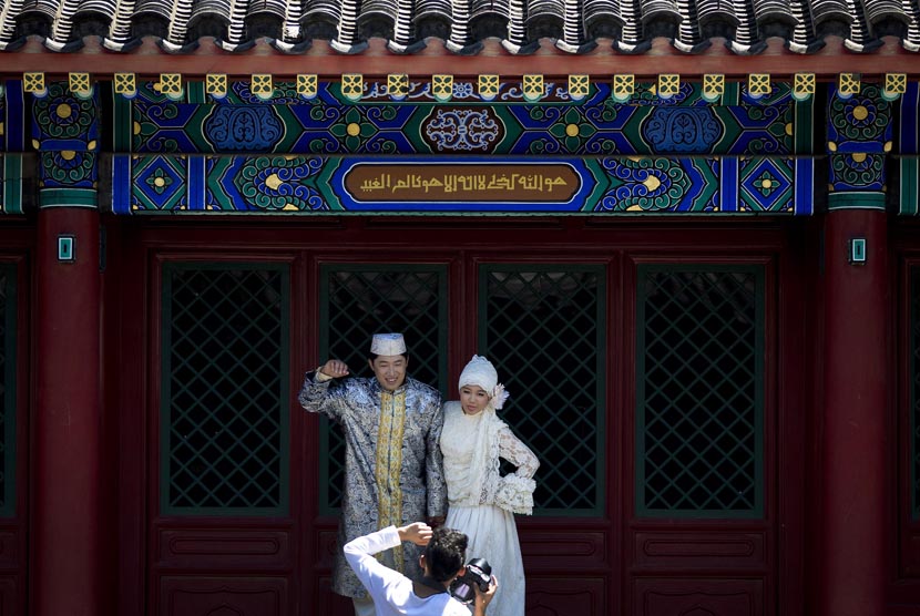 Pasangan pengantin baru berpose untuk difoto di Masjid Niujie, Beijing, Selasa (16/7).(AP/Andy Wong)