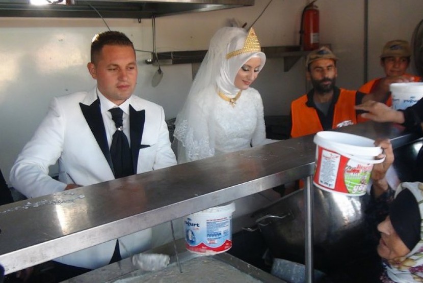 Pasangan pengantin dari Turki, Fethullah Üzümcüo?lu bersama istrinya Esra Polat mendistribusikan hidangan pernikahan mereka kepada 4.000 pengungsi Suriah.