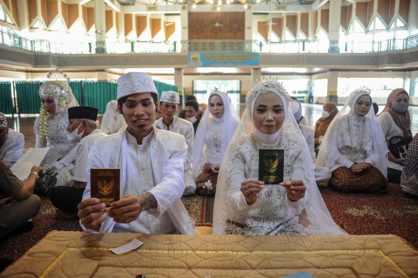 Pasangan pengantin menunjukan buku nikah saat mengikuti nikah massal (ilustrasi). Badan Pusat Statistik (BPS) Kabupaten Bogor, Jawa Barat, mencatat baru 45,21 persen pasangan suami istri di Kabupaten Bogor yang tercatat negara dan memiliki akta nikah.