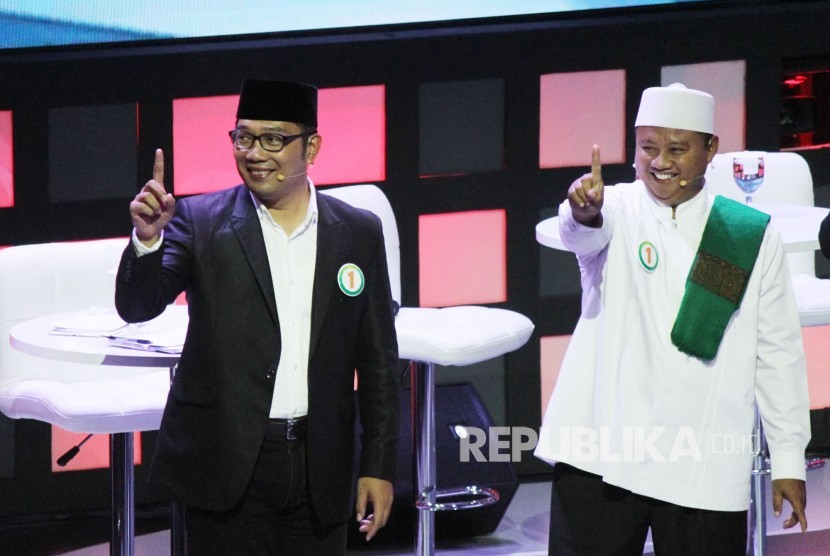 Pasangan Ridwan Kamil dan Uu Ruzhanul Ulum menyampaikan paparannya saat Debat Publik Pertama Pilgub Jawa Barat 2018 bersama empat pasangan calon gubernur dan wakil gubernur Jawa Barat, di Gedung Sabuga, Kota Bandung, Senin (12/3).