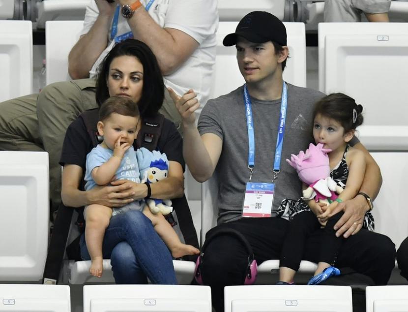 Pasangan selebritas Hollywood Ashton Kutcher dan Mila Kunis memangku anaknya saat menonton FINA Swimming World Championships 2017. Pasangan selebritas Hollywood ini menggalang dana untuk Ukraina, kampung halaman Kunis.