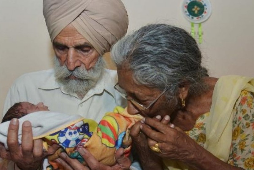 Pasangan suami istri, Daljinder Kaur (kiri) bersama sang suami Mohinder Singh Gill saat menggendong bayi kesayangan mereka di Amritsar, India, Rabu (11/5).