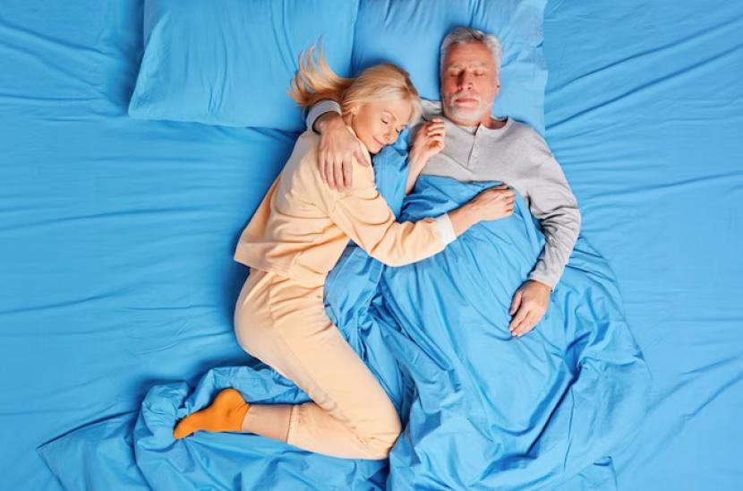 Pasangan suami-istri tidur. Posisi tidur seperti ini memang lebih romantis, tetapi tak terlalu bagus untuk penyelarasan tulang belakang.