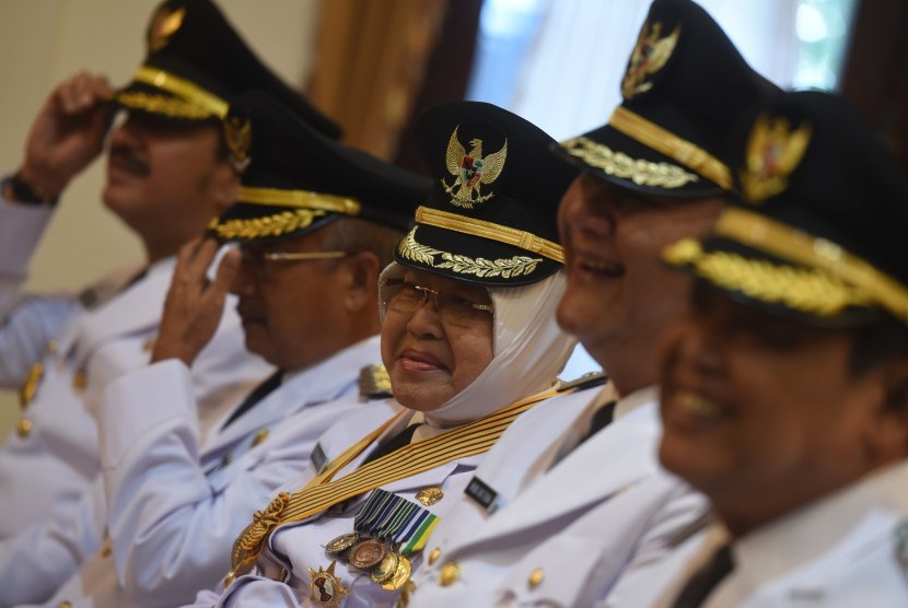 Pasangan Wali Kota/Wakil Wali Kota Surabaya terpilih Tri Rismaharini (tengah) dan Wisnu Sakti Buana (kedua kanan) tersenyum bersama sejumlah bupati/wakil bupati terpilih lainnya ketika mengikuti pelantikan  gelombang kedua di Gedung Grahadi, Surabaya, Jawa