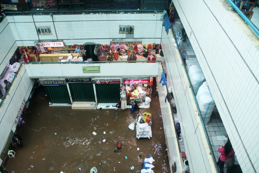 Pasar Cipulir Tergenang Banjir: Pedagang melakukan aktivitas perdagangan di Pasar Raya Cipulir yang masih digenangi air, Jakarta Selatan, Selasa (21/1). Banjir yang disebabkan curah hujan tinggi dan meluapnya kali Pesanggrahan tersebut membuat aktivitas pe