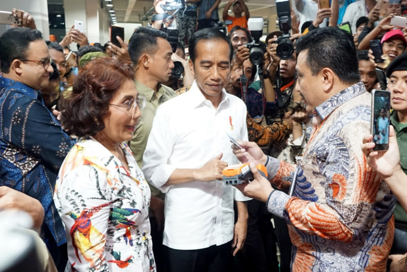 Pasar Ikan Muara Baru. Presiden Jokowi didampingi Menteri Kelautan dan Perikanan Susi Pudjiastuti menjajal mesin EDC BNI.