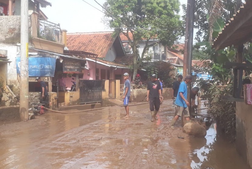 Pasca banjir, puluhan warga di Kelurahan Andir, Kecamatan Baleendah mulai membersihkan sisa lumpur yang terbawa banjir di jalan Andir-Katapang dan pemukiman warga, Selasa (12/3).