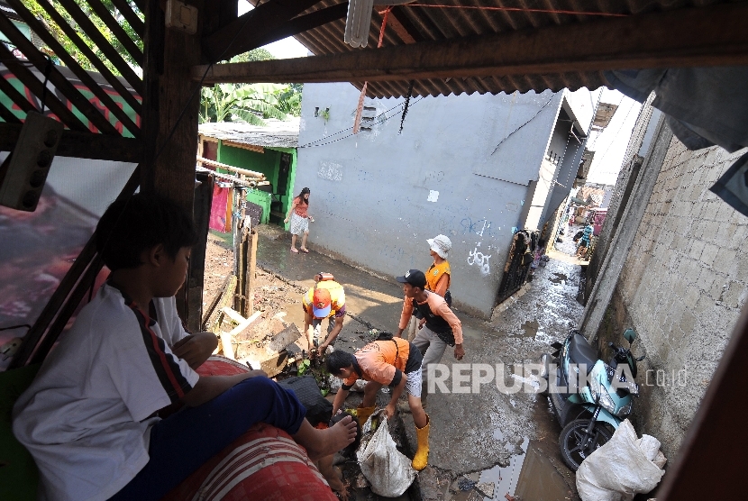 Petugas Penanganan Prasarana dan Sarana Umum membersihkan sampah pasca banjir yang diakibatkan tanggul jebol di Jatipadang, Pasar Minggu, Jakarta Selatan, Jumat (20/10).