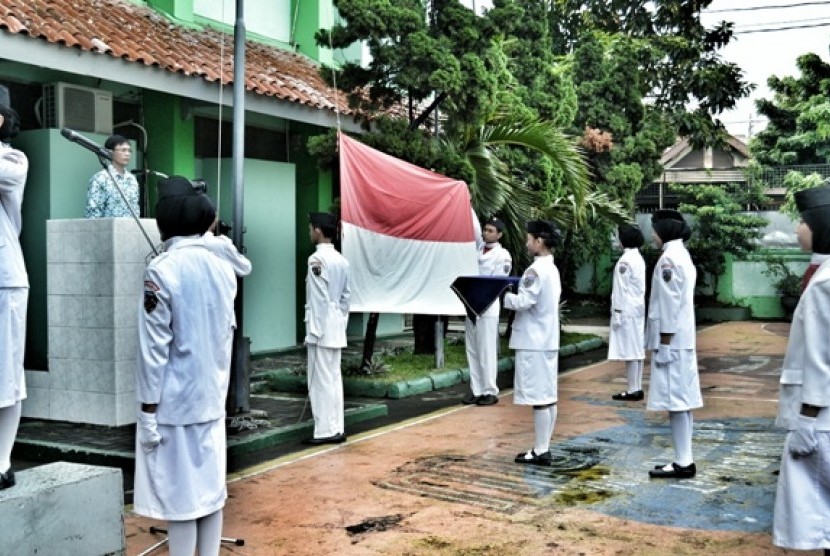 Paskibra mengibarkan Sang Merah Putih dalam Upacara Peringatan Hardiknas 2013 di SMAN 12 Jakarta.
