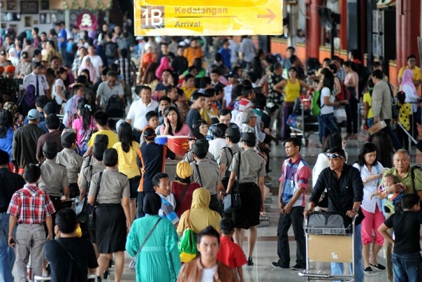 Passenngers exit from arrival gates in Soekarno Hatta Airport in Tangerang on Sunday, August 11, 2013, during returning trip season after Eid al Fitr holidays. 