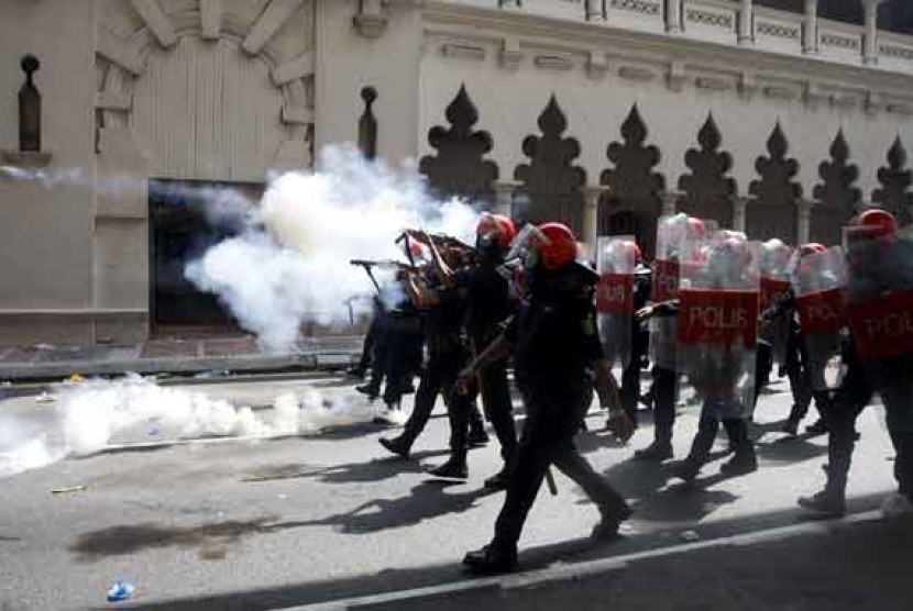 Pasukan anti huru hara menembakkan gas air mata ke arah massa pengunjuk rasa di Kuala Lumpur, Malaysia, Sabtu (28/4). 