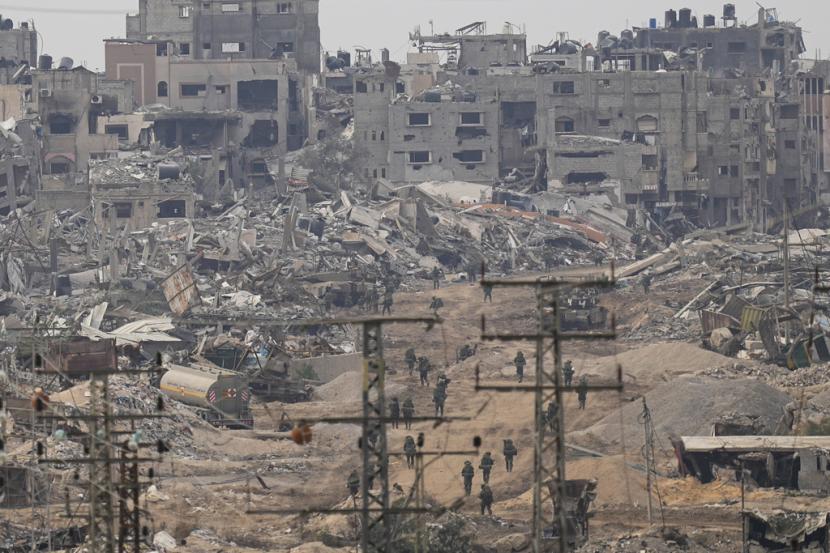 Pasukan Israel berjalan di Jalur Gaza terlihat dari Israel selatan, Kamis, 21 Desember 2023.
