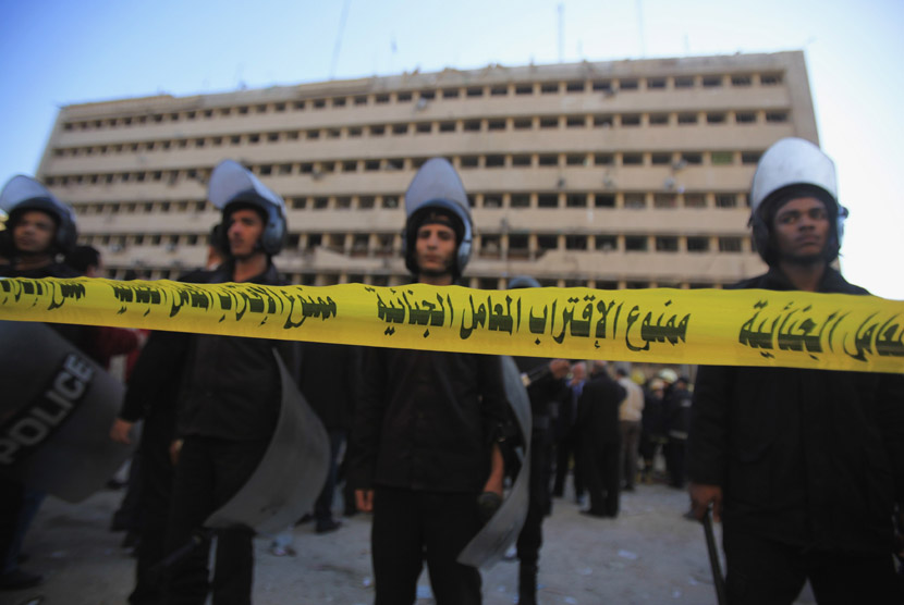  Pasukan keamanan menjaga markas polisi yang hancur akibat diserang ledakan bom mobil di pusat kota Kairo, Mesir, Jumat (24/1).    (Reuters/Amr Abdallah Dalsh)