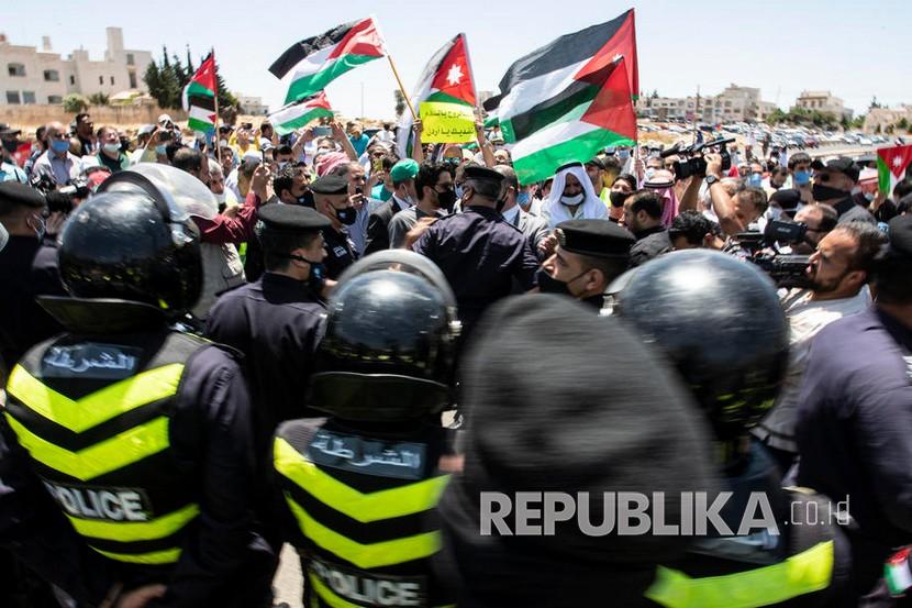 Pasukan keamanan Yordania mengamankan aksi unjuk rasa menentang rencana Israel untuk mencaplok  bagian Tepi Barat Palestina, di dekat Kedutaan Besar AS,  Amman, Yordania, Jumat (3/7).
