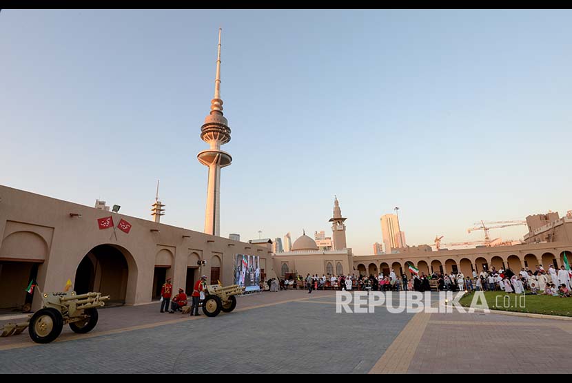 Pasukan militer Kuwait dan warga setempat memasuki istana untuk menyaksikan tradisi  menembakan meriam kosong sebagai tanda berbuka puasa di Istana Naif, Kuwait City, Kuwait, Senin (21/5)  waktu setempat