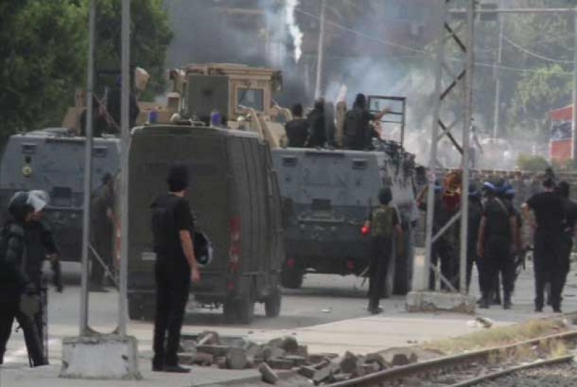 Pasukan militer Mesir melemparkan gas air mata ke arah pendukung Presiden Mursi di Kairo, Rabu (14/8).