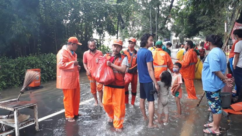 Pasukan Orange membantu warga yang terendam banjir di sekitar jalan Duren Bangka pada Sabtu (20/2). Banjir terjadi karena luapan kali mampang
