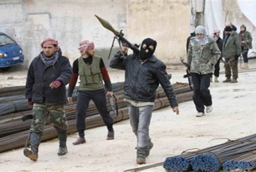 Pasukan pemberontak Suriah berjalan di sebuah kawasan di Idlib, Suriah, Kamis (9/2). 