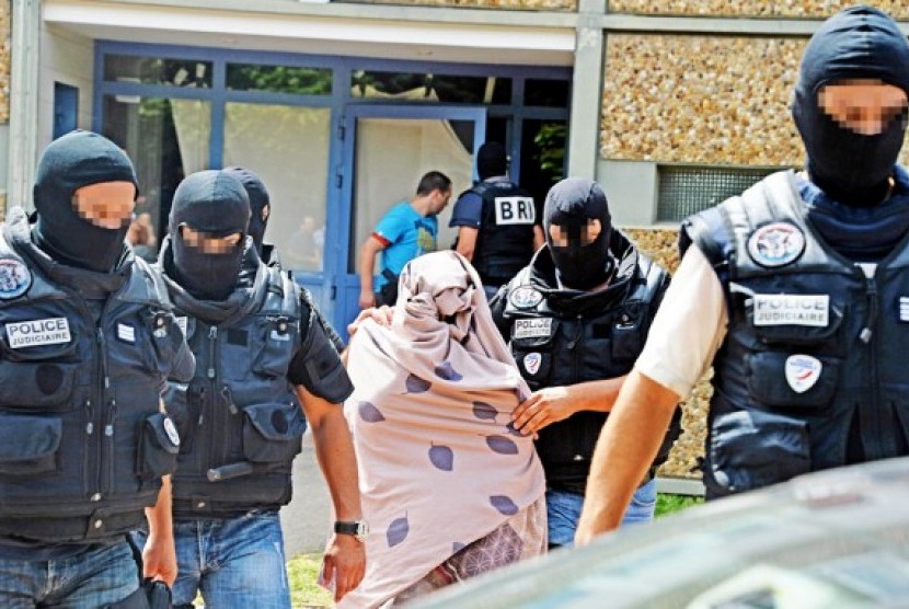 Pasukan Polisi mengawal seorang wanita tak dikenal saat mereka mencari rumah tersangka pemenggal kepala, Yassin Salhi di Saint-Priest dekat Lyon, Prancis