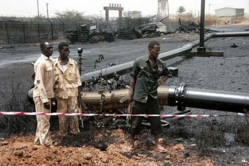  Pasukan Sudan mengamati pipa minyak yang terbakar akibat serangan bom di kota Heglig, Sudan, Kamis (24/4) lalu.