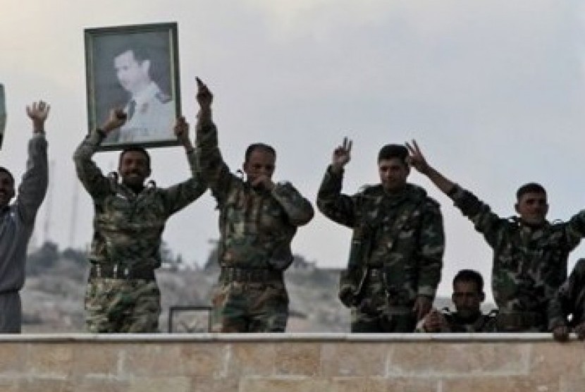 Pasukan Suriah membawa poster Presiden Suriah, Bashar al Assad