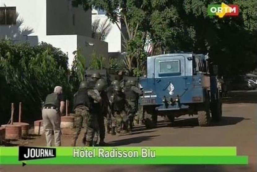 Pasukan tentara Mali mendekati lokasi Hotel Radisson Blu  di Bamako, Mali, Jumat (20/11).  (AP/Mali TV)